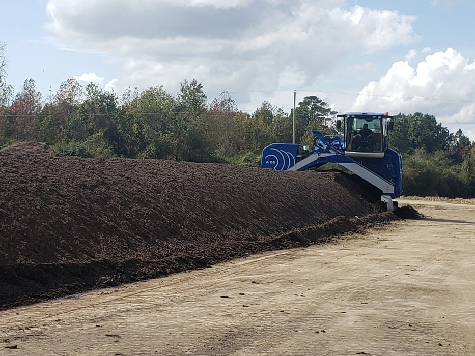 Compost windrow and the equipment used for turning (row turner)