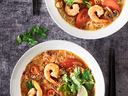 Soups with shrimp, vegetables, and a lime.