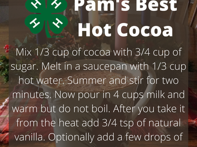 Pam's Best Hot Cocoa recipe card over a mug with lit candles in background