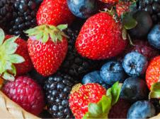 Assorted strawberries, blueberries, blackberries, and raspberries in a woven basket