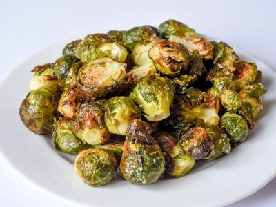 Roasted Brussels sprouts piled on a white plate