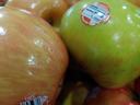 Close-up of red and green apples with barcode stickers showing "3283"