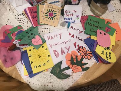 Handmade Valentine's Day cards spread on a table; central card reads "HAPPY Valentine's DAY"