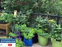 Container herb and vegetable garden on balcony railing; NC Cooperative Extension logo