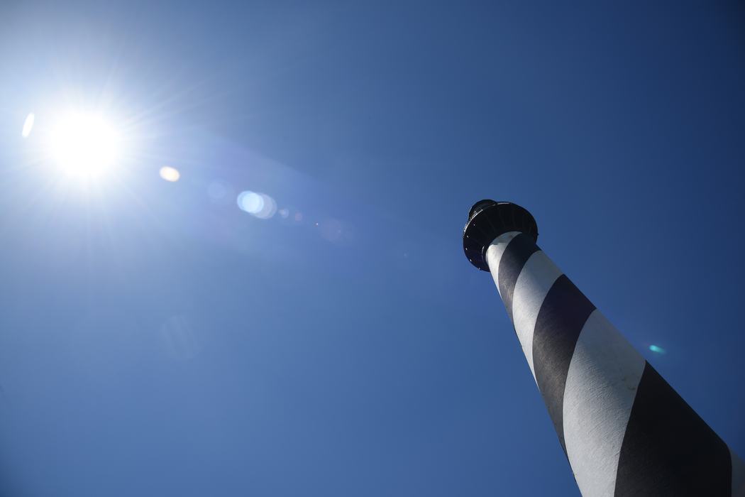 The Cape Hatteras Lighthouse stands as a beacon along the Outer Banks. The sun is lined up perfectly with the lighthouse.