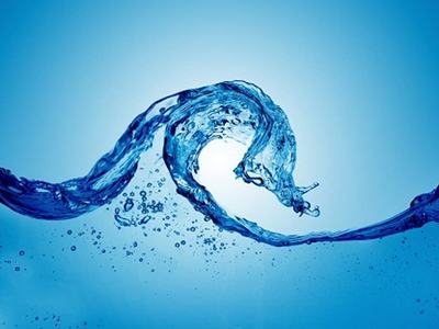 Curving blue water splash forming a wave with scattered droplets on a light blue background