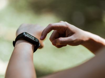 a watch on an arm with a hand pointing a finger