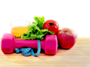 Pink dumbbell, blue measuring tape, lettuce, tomato, apple, and glass of juice on wood