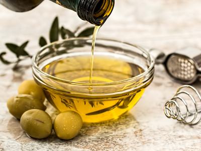 Yellow Olive Oil Being Poured into a Small Glass Bowl