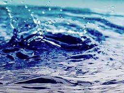 Blue water surface with central splash and concentric ripples