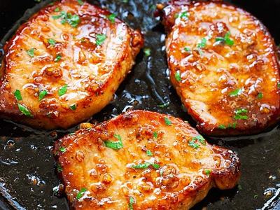 3 pork chops in a black skillet pan