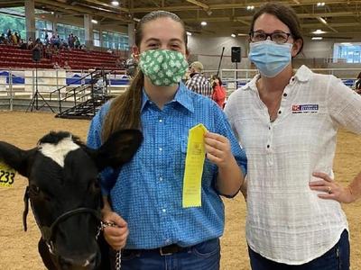 A female 4-H'er stands with her dairy steer and North Carolina Cooperative Extension 4-H Agent Holly Jordan during the 2020 WNC Livestock Expo.