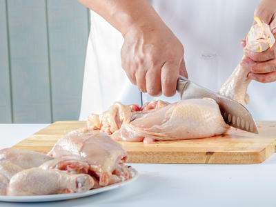 chef cutting raw chicken