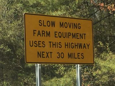 Yellow sign reading: SLOW MOVING FARM EQUIPMENT USES THIS HIGHWAY NEXT 30 MILES