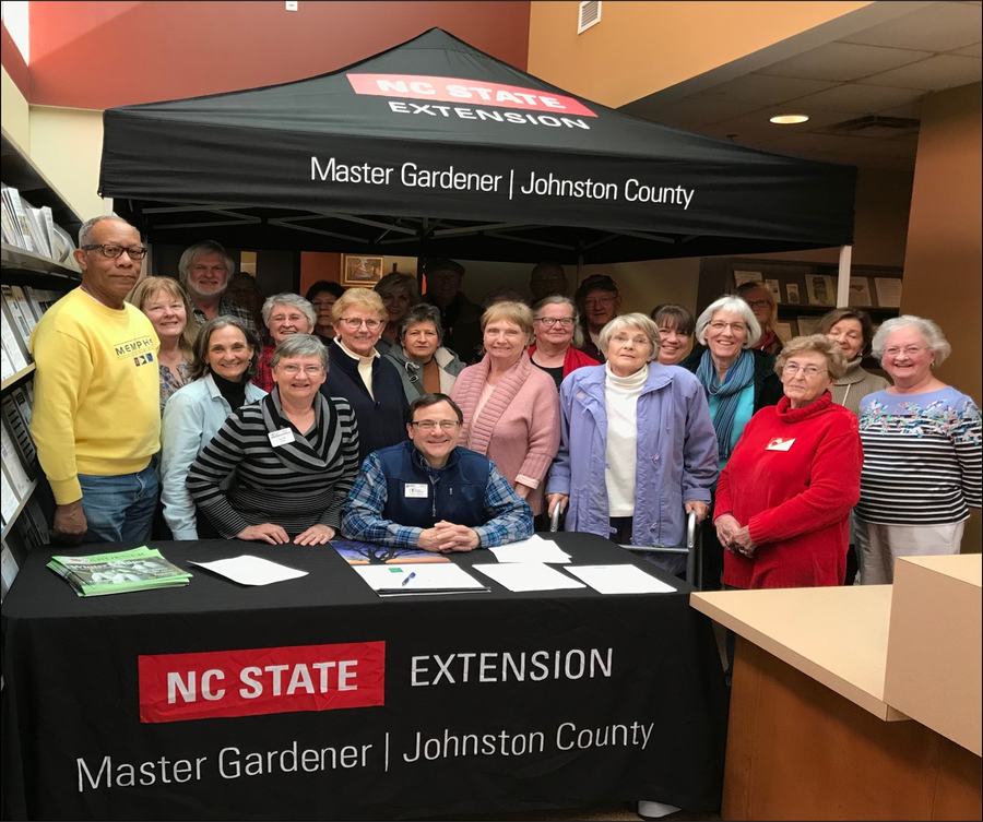 group of adult volunteers gathered behind a table