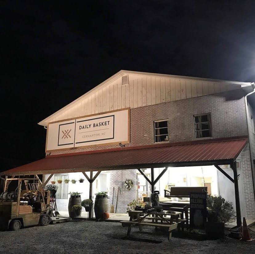 Daily Basket storefront lit up at night