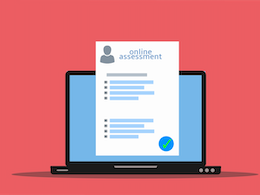 laptop computer and a assessment paper on top