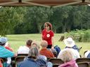 Woman in Red Shirt Teaching People about Agriculture