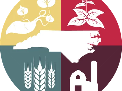 Circle emblem: North Carolina silhouette surrounded by sweet potato, tobacco, wheat, barn.