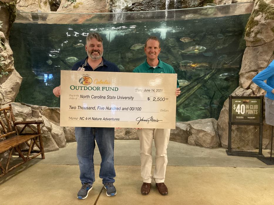 Two men holding big check