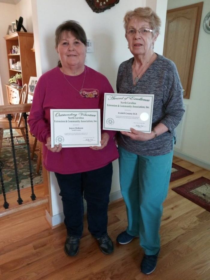 Two women holding awards