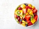 Bowl of mixed fruit: strawberries, kiwi, mango, pineapple, orange, grapes, blueberries