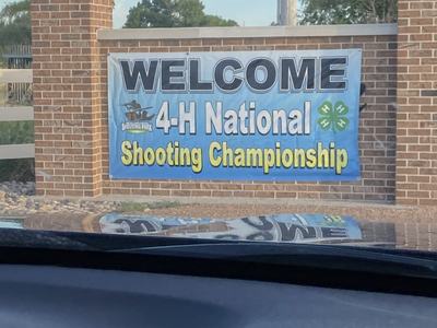 Welcome "4-H National Shooting Championship" banner mounted on brick wall