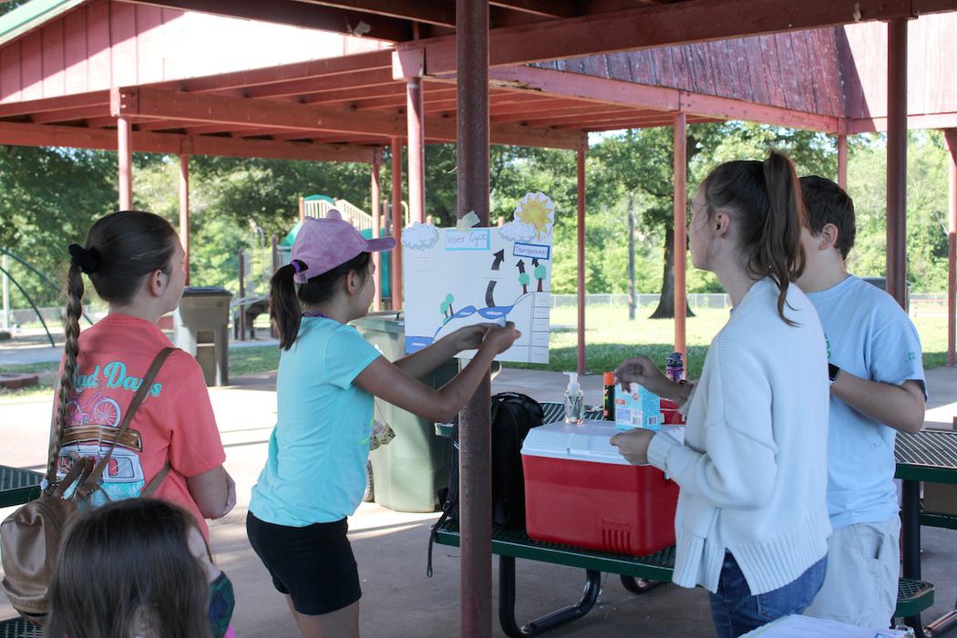 Youth work together to complete a model of the water cycle and describe the importance of each component.