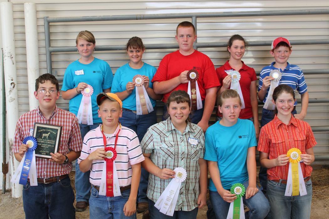 Children posing with award ribbons and plaques. 