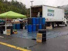 EcoFlo truck with tent collecting blue barrels and containers at outdoor drop-off