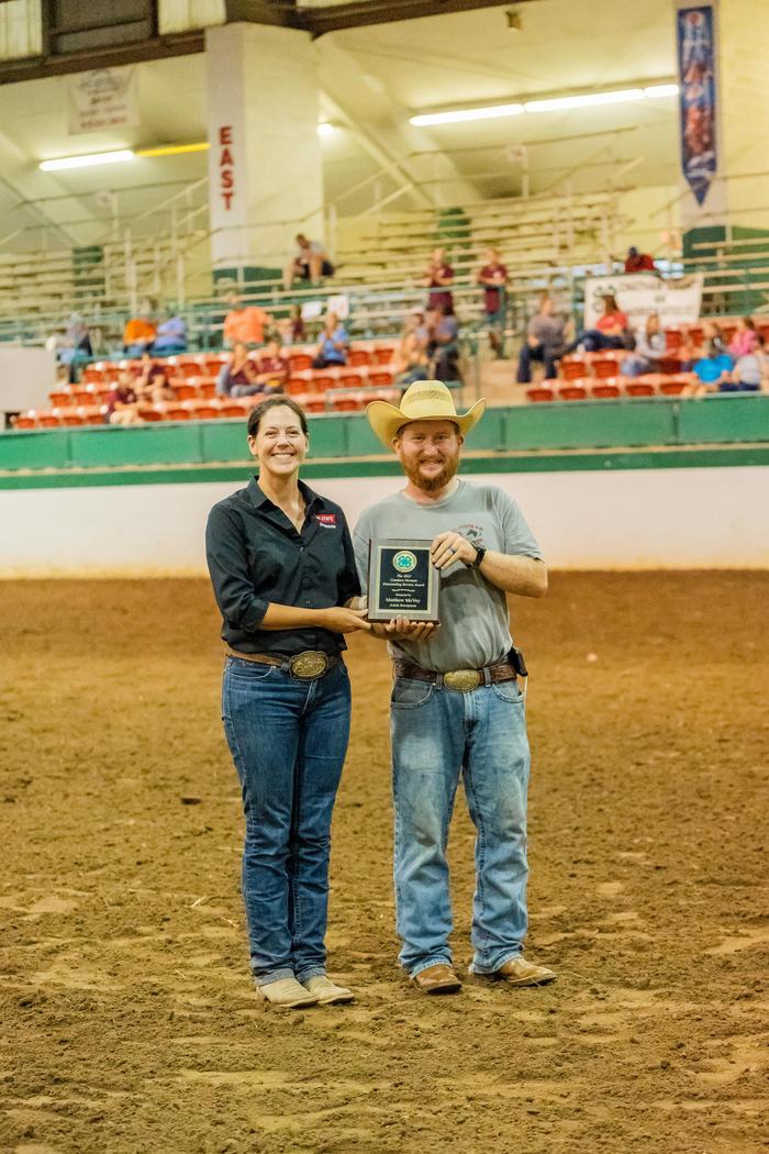 Man and woman holding a plaque