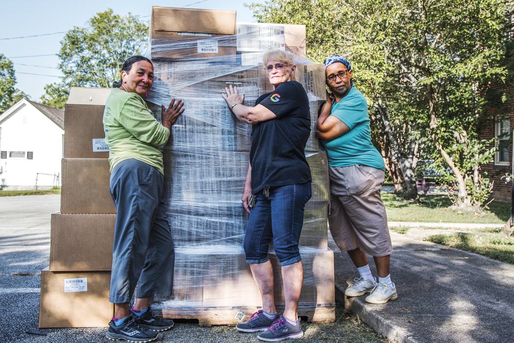 Three women leaning on boxes