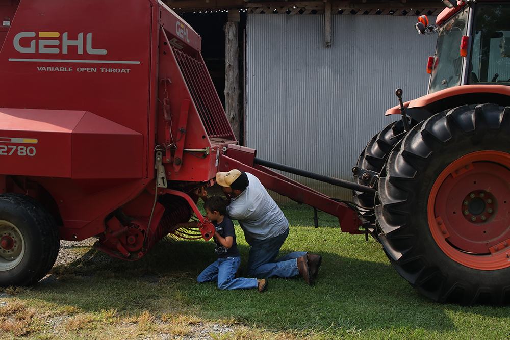 Man looking at hay bailer