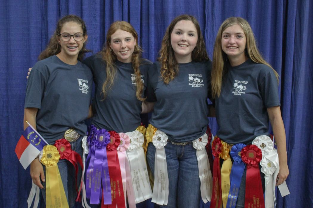Four young women wearing many award ribbons and shirts reading "Southern Regional DELEGATE."