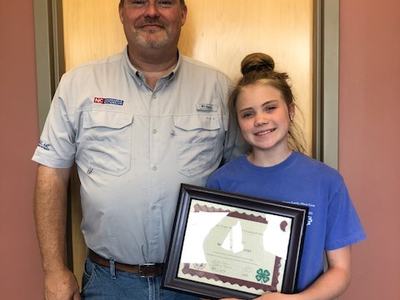 4-H'er holding certificate with local Extension Director