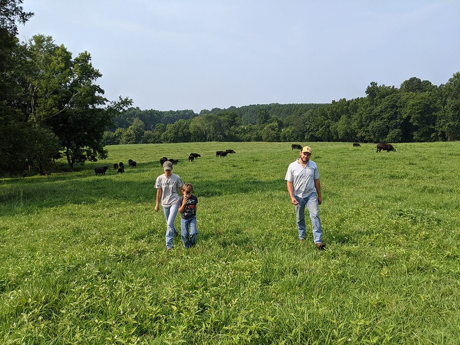 Three people walking in field
