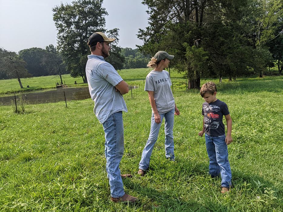 Three people standing in field