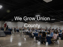 We Grow Union County in front of picture of people at a dinner
