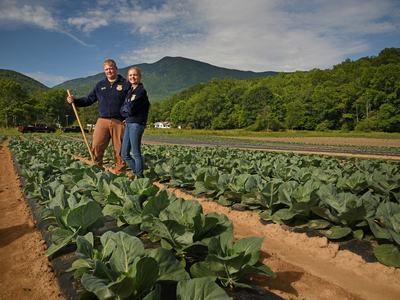 2 people standing in field with collards