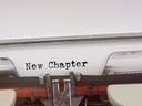 Typewriter paper with the text "New Chapter" typed in black
