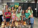 Group of children posing at a fair booth with signs reading "Barnyard Bandits", "PIG", "HORSE"