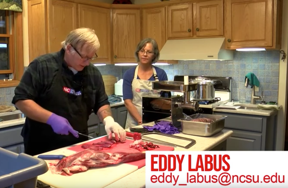Man cutting meat on counter