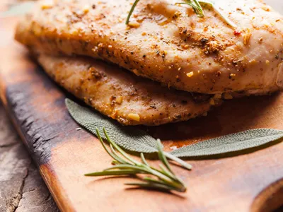 Baked Chicken Breasts with Herbs on a Cutting Board