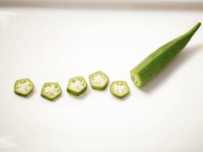 A piece of partially sliced okra on a white plate