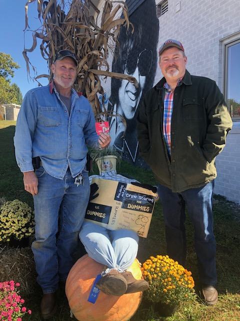 contest winner in front of fall display with certificate and county extension director