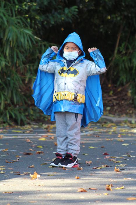 Young boy in a blue Batman raincoat