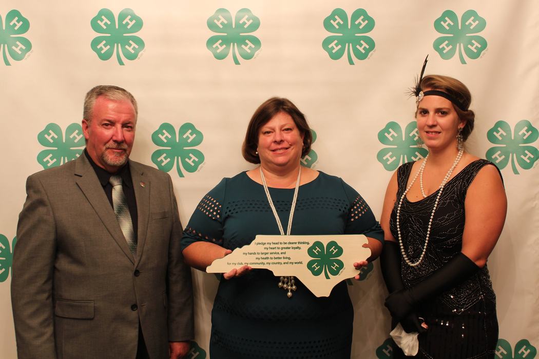 3 adults looking at camera