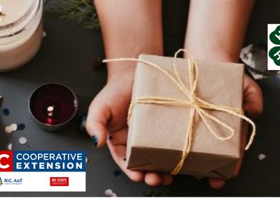 Hands holding tied brown gift box with NC Cooperative Extension logo.