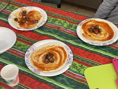 Three paper plates with tortillas swirled with red sauce and small meat pieces