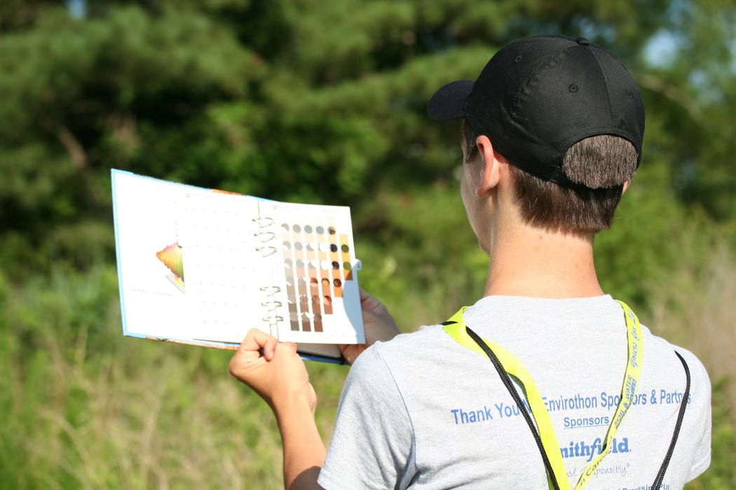 Youth holding munsell soil chart to determine color of soil